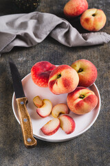 Fresh ripe sliced peaches and a knife on a plate on the table vertical view