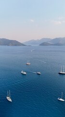 Obraz premium Sunset coastal city. Boats coastal town. Coastal mountain landscape, sea resort yachts, golden hour