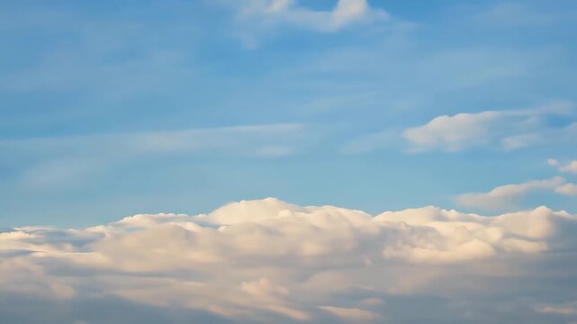 Soft daylight timelapse of scattered puffy clouds rolling over bright sky