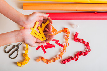 Female hands holding strips of paper to make a handmade paper chain