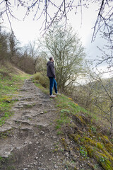 Man stands outdoors with calm expression surrounded by a serene landscape