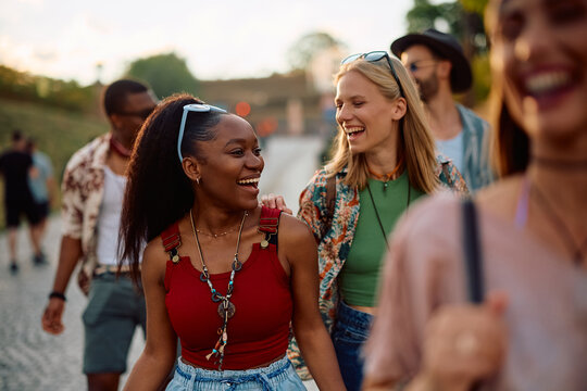 Cheerful female friends enjoying in summer while attending open air music festival. - Powered by Adobe