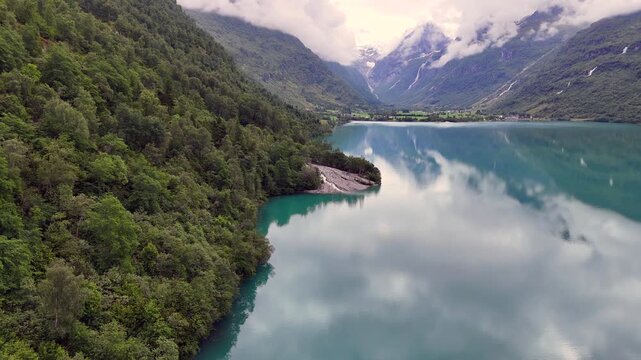 Aerial view of calm Oldevatnet lake in Oldedalen valley, framed by steep mountains near Olden