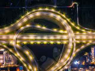 Aerial view of illuminated cloverleaf interchange over canals at night