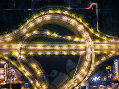 Aerial view of illuminated cloverleaf interchange over canals at night