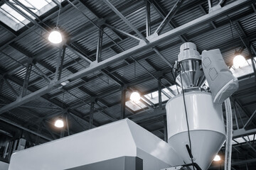 industrial PVC extrusion machine against industrial metal roof with lighting