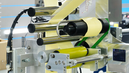 Fragment of the conveyor of sticking labeling machine. Abstract industrial background.