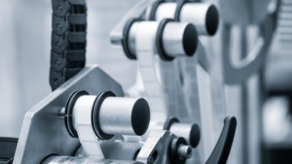 Fragment of the conveyor of sticking labeling machine. Abstract industrial background.