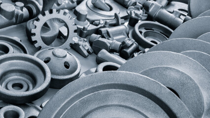 Collection of metal parts, including nuts and bolts. Some of the parts are silver and some are dark...