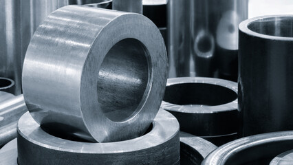 Collection of metal cylinders with one of them being silver. The silver cylinder is in the middle of the other cylinders