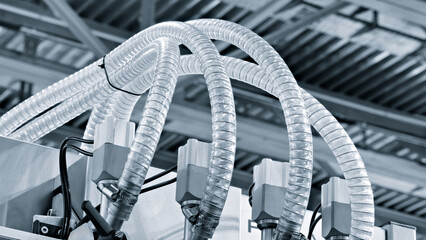 Close-up of precise industrial equipment with pneumatic components: plastic tubes with connectors....
