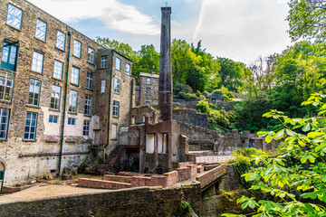 A  view towards a disused mill beside the Torrs Riverside walkway at New Mills, High Peak in the UK in summertime © Nicola