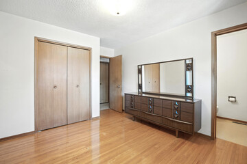 Bedroom with a wooden dresser and a mirror