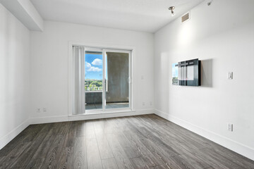 Large open living room with a large window overlooking a city