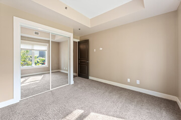 Large, empty room with a white door and a window