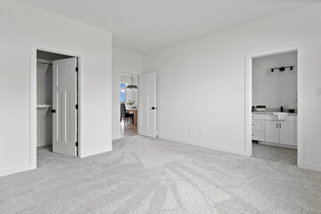 Large, empty room with a white door leading to a closet