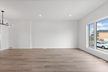 Large, empty room with a window and a car outside