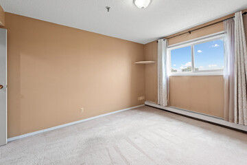 Room with a tan wall and a white curtain