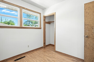 Small, empty room with a wooden door and a window