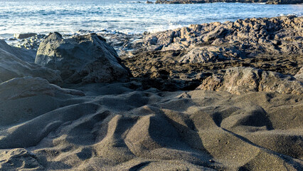 Playa de la Arena, Canary Islands, Tenerife, Spain. Beach with black volcanic sand. Atlantic coast. Beautiful landscape. The unique tropical climate allows swimming all year round.