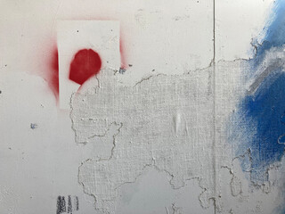 Random paint marks left on a section of wall in an art studio