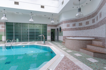 The serene indoor swimming pool showcases a tranquil environment with contemporary design elements,...