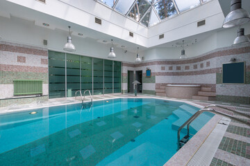 Indoor swimming pool with modern design and skylight illumination in a tranquil environment for relaxation and leisure activities