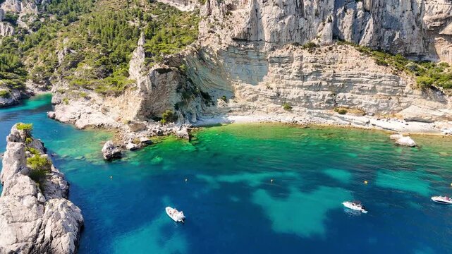 Vid&eacute;o a&eacute;rienne d'un paysage paradisiaque de vacances avec une mer bleue et turquoise et une falaise avec des arbres, pendant l'&eacute;t&eacute; 