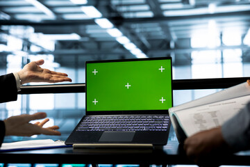 System administrators in data center using chroma key green screen laptop, refining server...