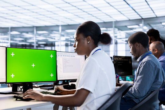 Woman in data center updating systems on isolated screen PC to protect servers from exploitable software vulnerabilities. African american IT specialist using mockup computer to look for errors - Powered by Adobe