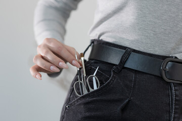 Manicure tools casually stored in jeans pocket, a stylish nod to a nail artist's everyday kit
