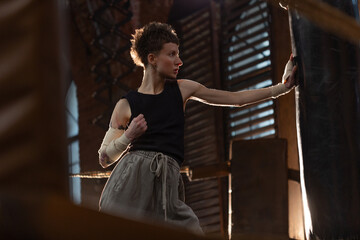Female boxer training in cinematic gym lighting, powerful punch on bag with colorful dynamic lights