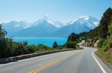 Scenic mountain road winds alongside brilliant blue lake towards snow-capped peaks. Rich green forests line route under clear, sunny sky. Picturesque journey offers stunning natural beauty, sense of