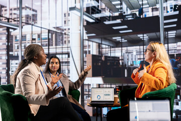 Multiethnic team of female entrepreneurs discussing business strategy for career development, women...