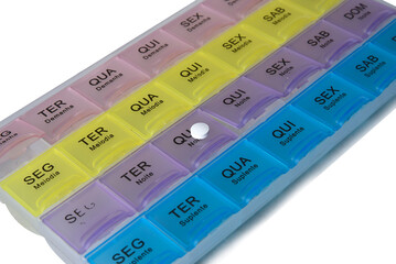 organized pill box with name in Portuguese of the days with pills isolated on white background