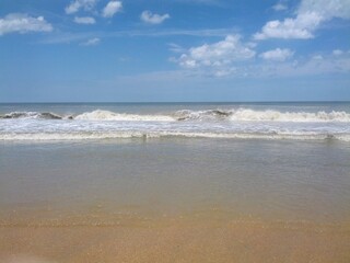 Tranquil Ocean View from Shoreline with Soft Waves and Clouds Over Beach Horizon