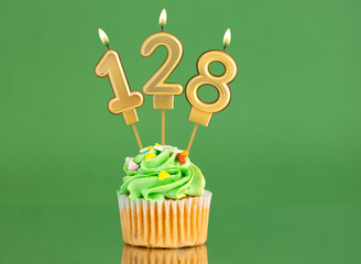 Number 128 birthday candle - Cupcake on a green background