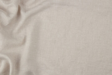 Soft draped beige linen background. Natural eco friendly fabric texture with draperies in left side