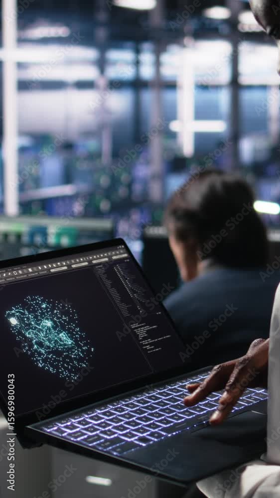Poster vertical video close up of data center technician using tablet to monitor neural network ai llm visu