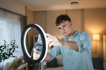 man v-logger set up mobile phone and ring light for live streaming
