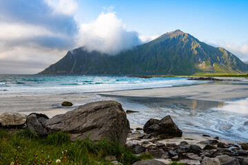 Beautiful Skagsanden beach and view of green mountains in summer in Flakstad, Lofoten Islands, Norway
