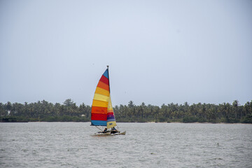 Trip in a small multi-colored sailboat on the lagoon in Abidjan