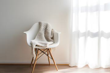 a chair with a blanket on it in front of a window