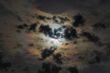 Sun shines through high clouds and creates dramatically brilliant multicolored halo