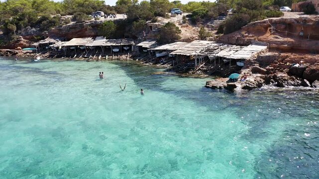 Aerial view of the small huts where the fishermen of Cala Saona keep their fishing boats, in Formentera, Spain.