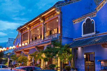 A vibrant blue-painted building illuminated at night, showcasing colonial architecture and cultural charm in the heart of the UNESCO World Heritage city.
