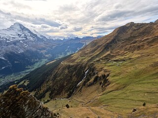 Tourists waiting their turn to take their picture of them in front of Eiger Mountain on the cliff walk at First Grindelwald Switzerland