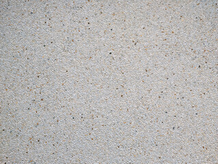 Top view of exposed aggregate surface with gravel stone in off-white cream and ochre tones with light cement or concrete for wall, slab, tile, floor, interior, exterior. Cladding, natural texture. 