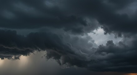 Obraz premium Dramatic dark storm clouds fill the sky with a hint of light breaking through.