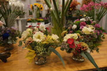 Autumnal flowers in Glass Vases adorn the shop's table at a Flower Market in Europe